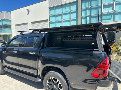 Passenger-side slotted shelf storage inside Toyota Hilux ute canopy